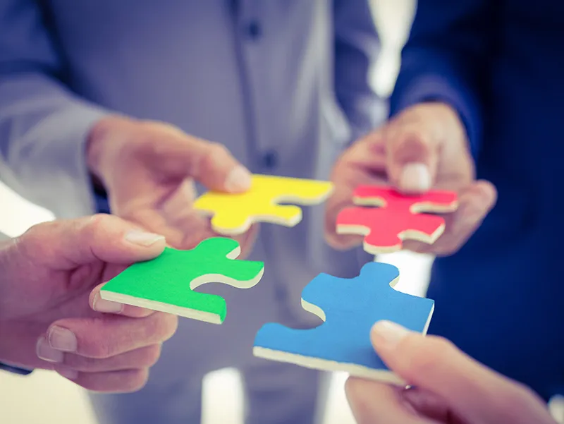 Four people putting a jigsaw together