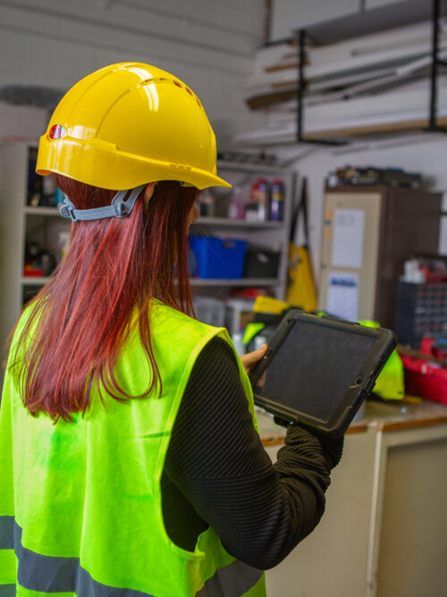 Woman using a clipboard and conducting checks on site.