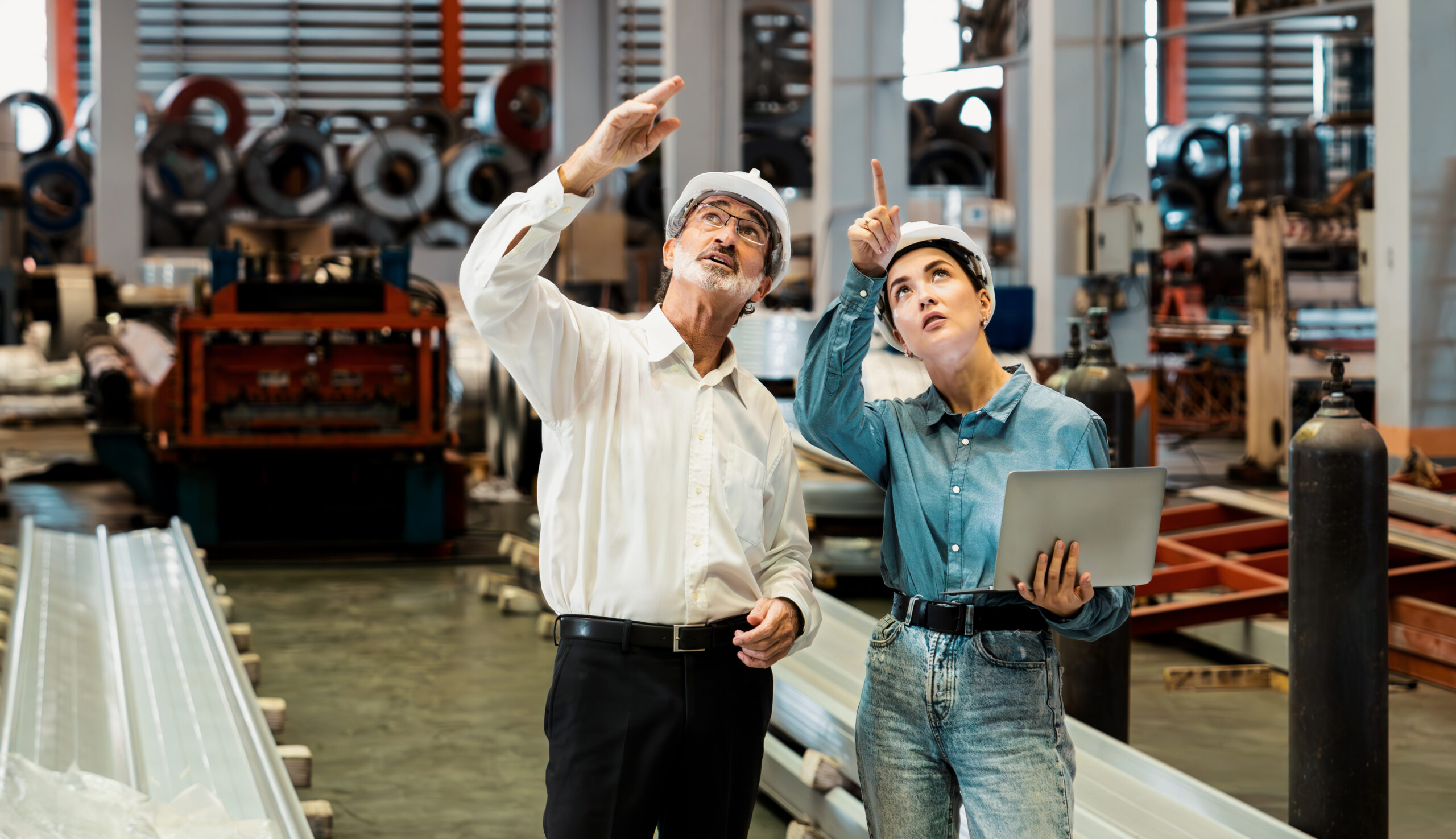 Two workers in a factory practising health and safety.